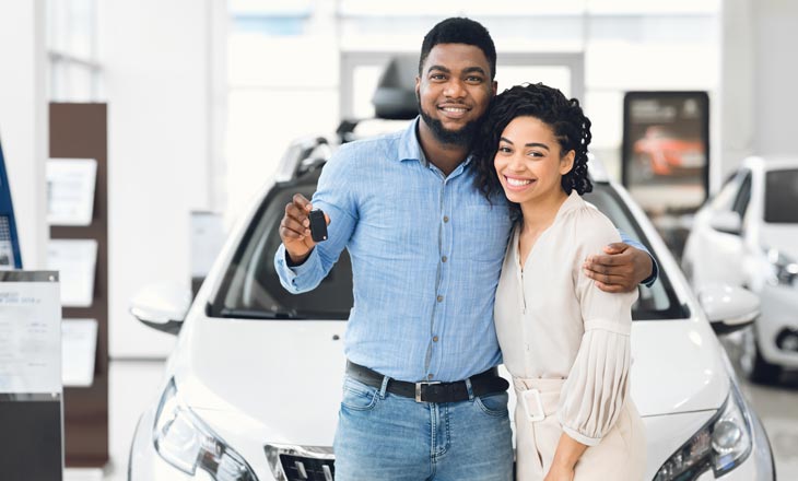 A happy couple after purchasing a car