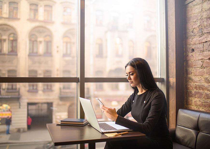 image of woman using phone and laptop