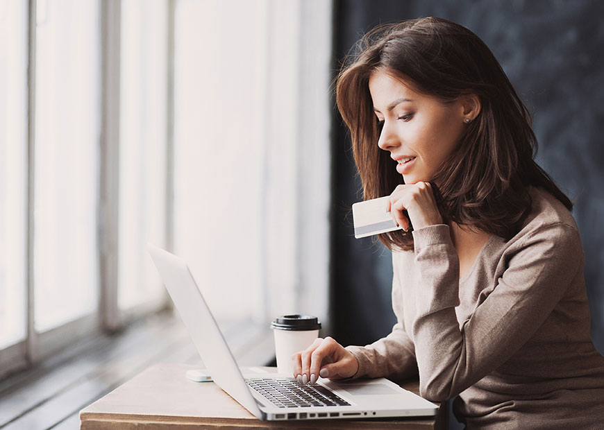 image of woman using laptop with credit card in hand
